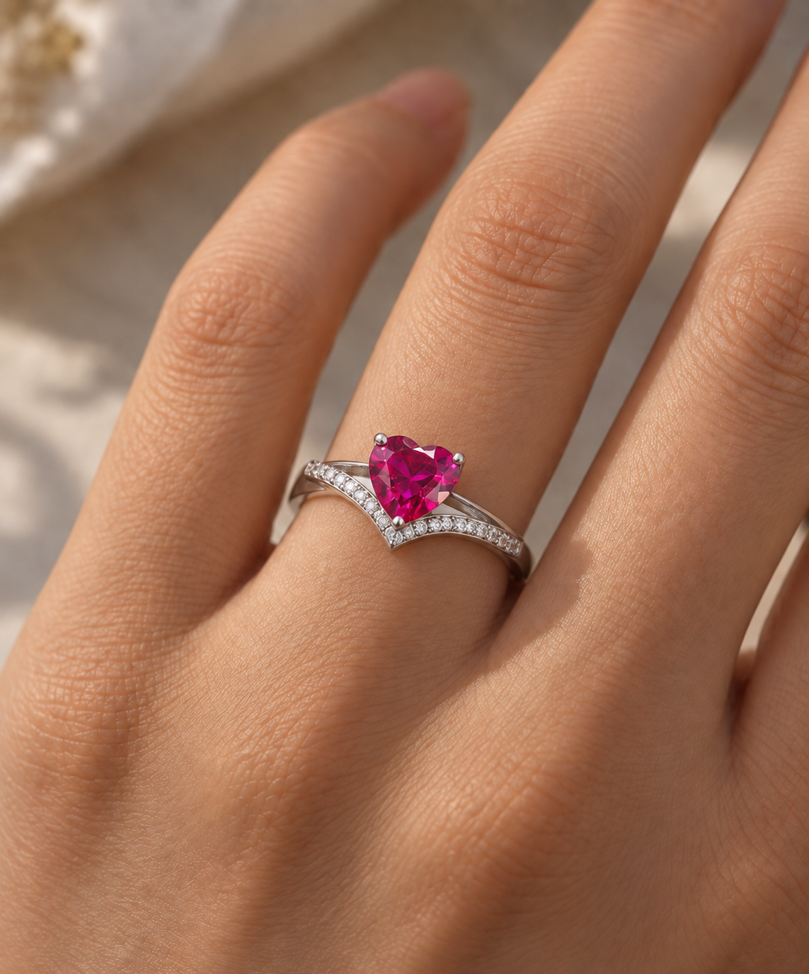 Fuchsia Heart Gemstone Ring in 925 silver featuring a vibrant heart-shaped fuchsia gemstone and sparkling V-shaped band accents, elegantly worn on the ring finger.