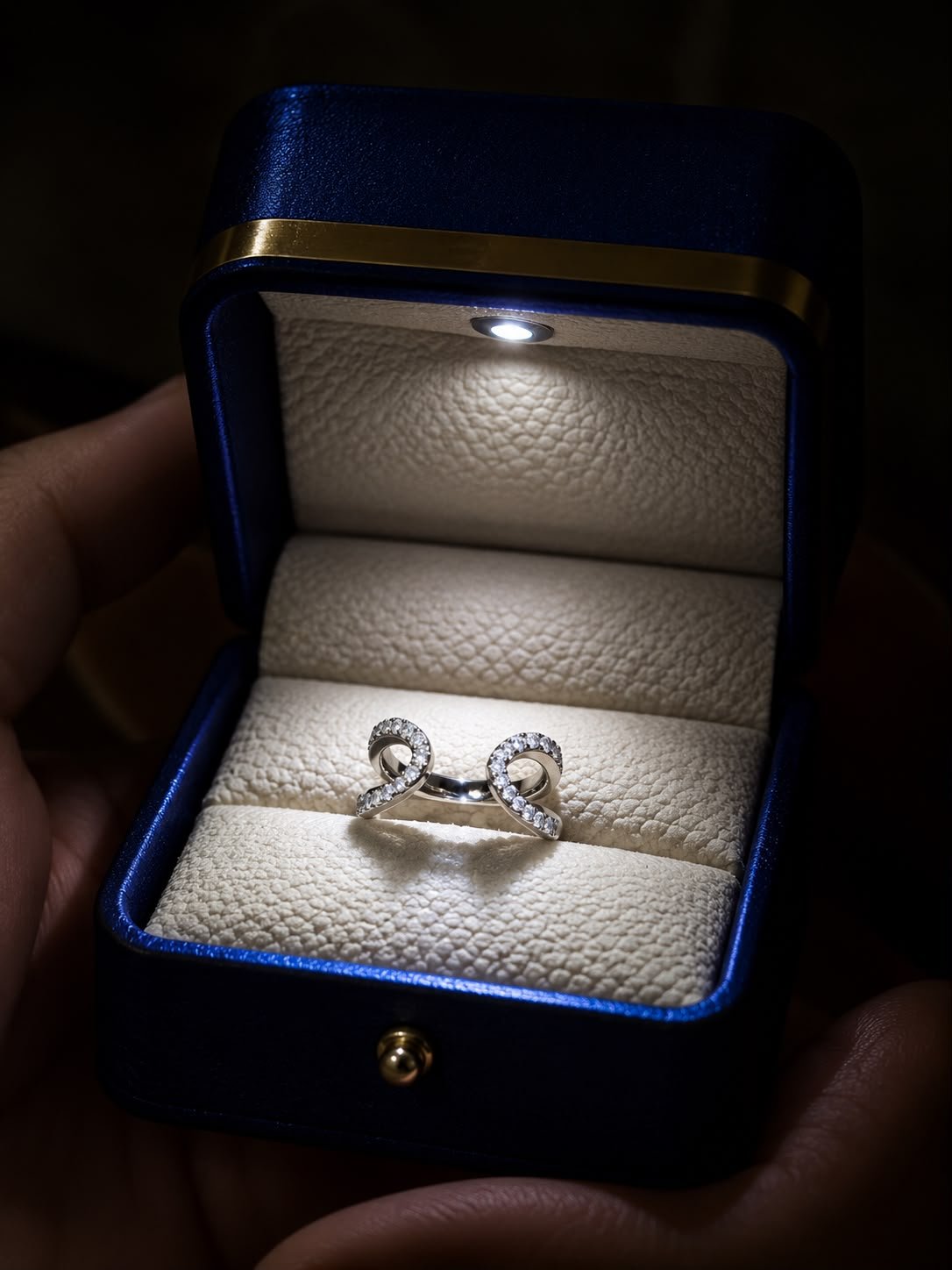 Mirrored Curve Pavé Ring featuring two open curved bands embellished with sparkling pavé-set stones displayed in a navy blue jewellery box.