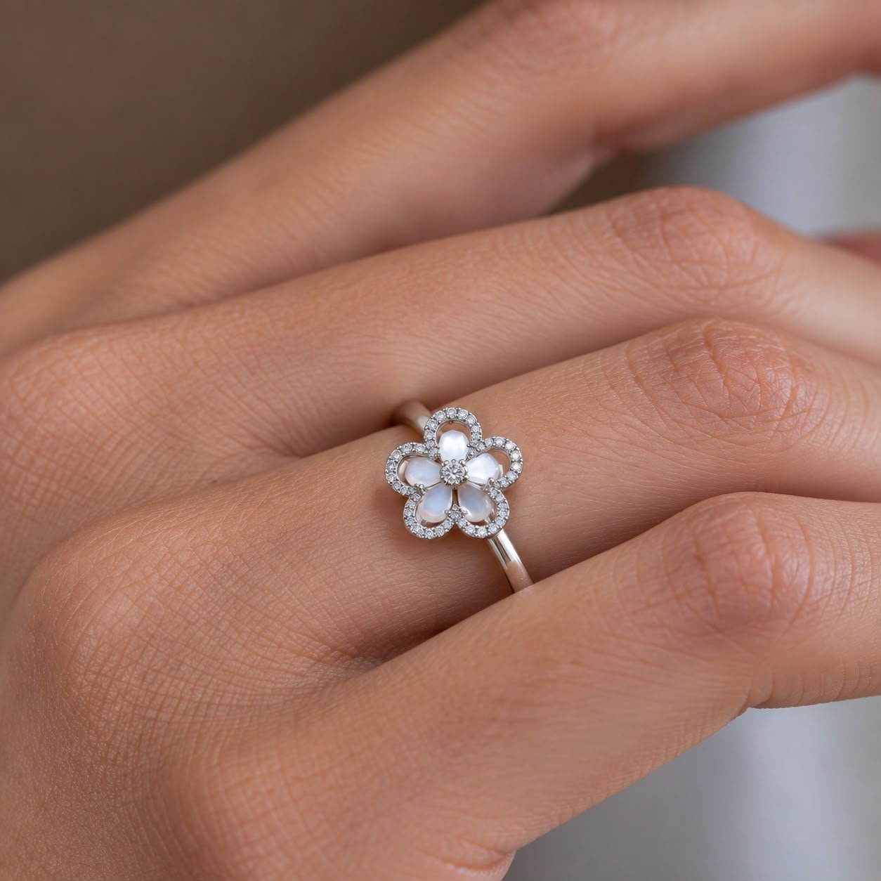 Close-up detail of the Blue Petal Halo Ring showing soft blue flower petals, a sparkling centre stone and pavé-set halo detailing.
