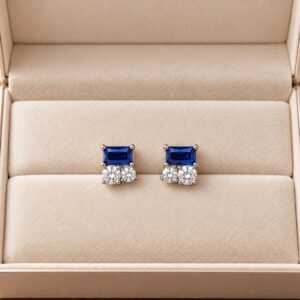 Royal blue gemstone stud earrings with two clear sparkling stones in a silver setting, front view in beige box