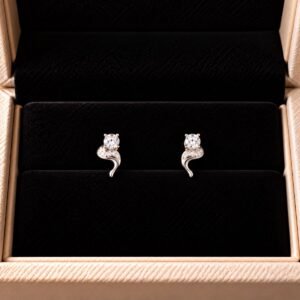 Diamond swirl earrings with pavé detailing on black velvet